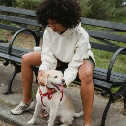 a woman sitting on a bench with a dog