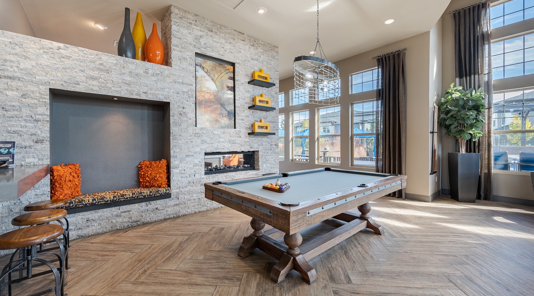 a clubhouse room with a pool table and a large window