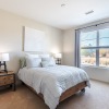 a bedroom with a nightstand, dresser and a window