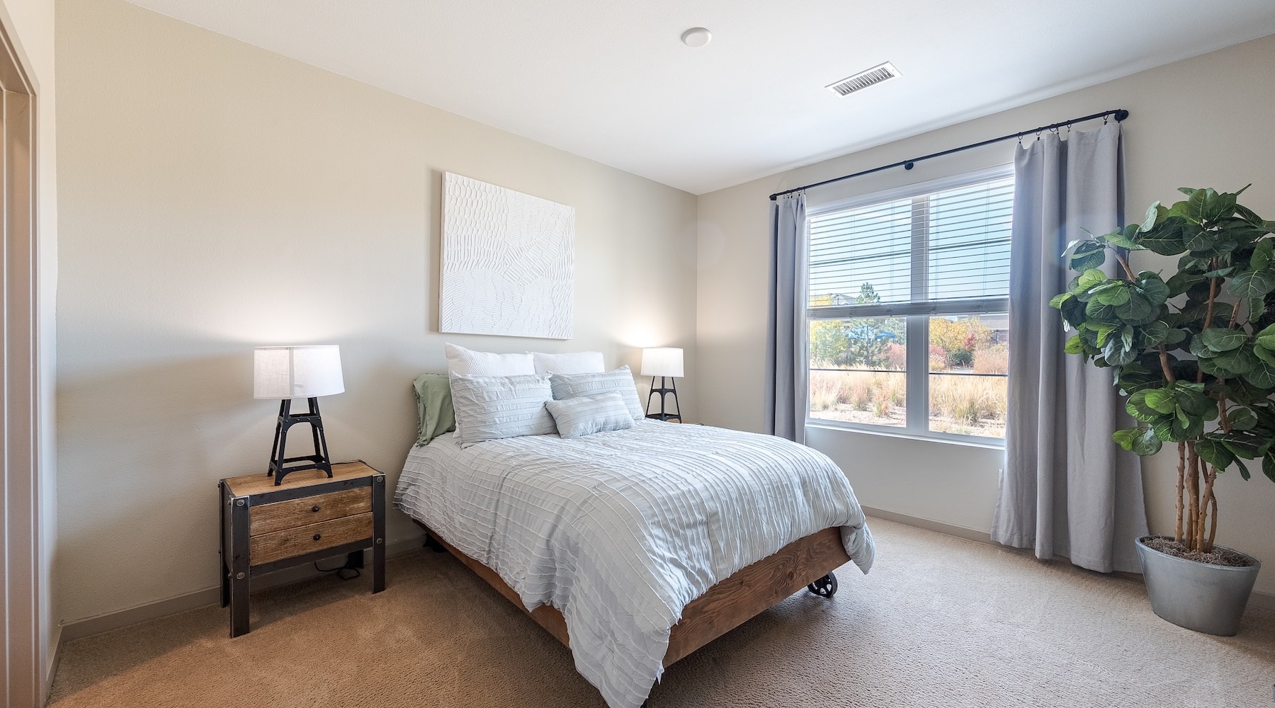 a bedroom with a nightstand, dresser and a window